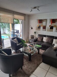 Living con ventanal hacia el patio y la piscina, casa en venta en Quilicura