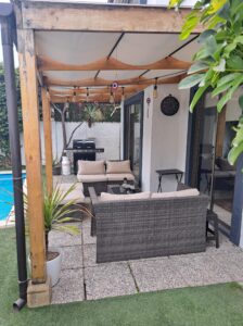 Pérgola con muebles de terraza junto a la piscina, casa en venta en Quilicura